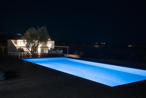 a swimming pool lit up at night at Andria's suites in Chrissi Akti