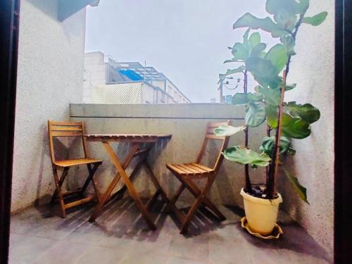 a table and two chairs and a potted plant on a balcony at 飄流葉民宿 in Yuli
