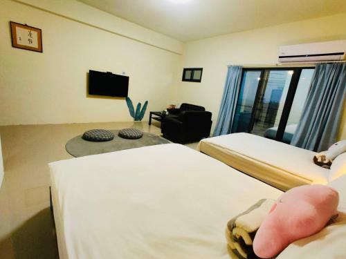 a hotel room with two beds and a tv at 飄流葉民宿 in Yuli