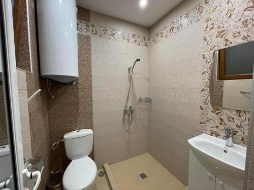 a bathroom with a toilet and a sink and a shower at Guest House Marchini in Sapareva Banya