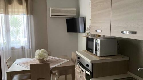 a small kitchen with a table and a microwave at Casa vacanze Rebecca in Chia