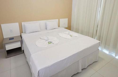 a bedroom with a white bed with a bow on it at Resort do Lago Oficial in Caldas Novas