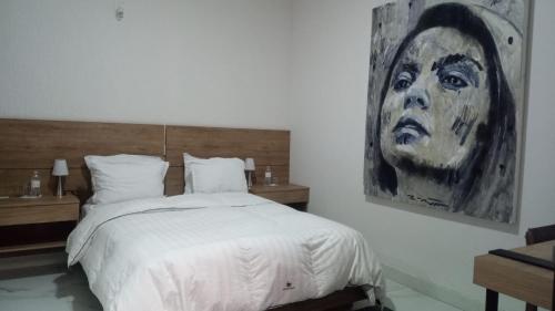 a bedroom with a bed and a painting on the wall at Vía Real Hotel Boutique in Atotonilco el Alto