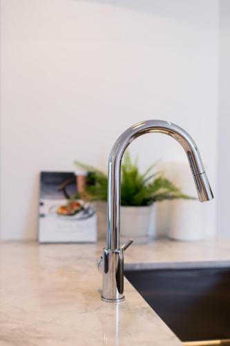 a kitchen sink with a chrome kitchen faucet at Little Italy Spacious 2 Bedroom Condo Free Parking in Montréal