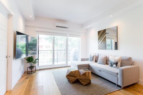 a living room with a couch and a large window at Little Italy Spacious 2 Bedroom Condo Free Parking in Montréal