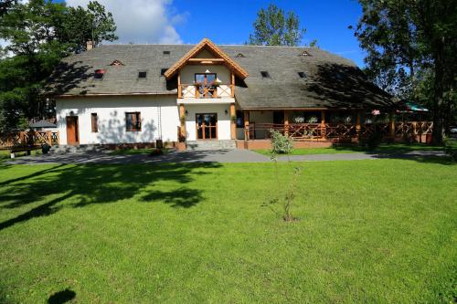 a large house with a thatched roof at Pensjonat Bajdarka in Suraż