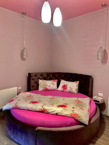 a bedroom with a large bed with pink sheets and pillows at Sweet Pink by Miro Apartment Early Checkin in Sinaia