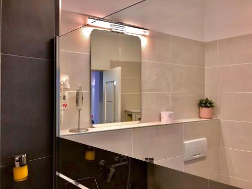 a bathroom with a mirror and a sink at Sweet Pink by Miro Apartment Early Checkin in Sinaia