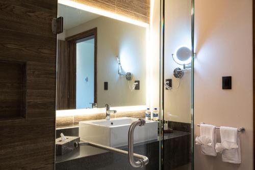 a bathroom with a sink and a shower with a mirror at Best Western Plus Riviera Veracruz in Veracruz