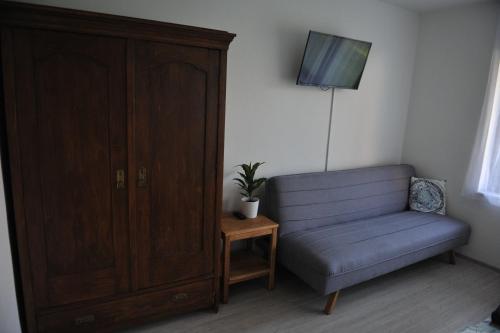 a living room with a chair and a tv and a cabinet at Apartmán Luční in Telč