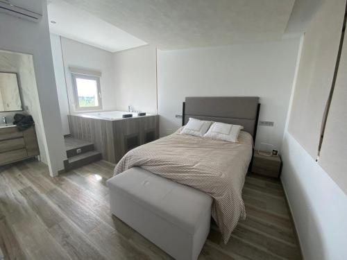 um quarto branco com uma cama e um lavatório em CASA SUITE JTG em Alicante