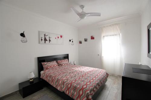 - une chambre avec un lit et un ventilateur de plafond dans l'établissement AlbufeiraSun, arrive as a guest leave as a friend., à Albufeira