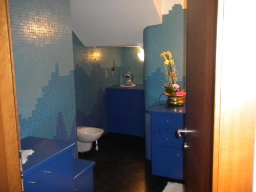 bagno blu con lavandino e servizi igienici di B&B fam. Ausermiller a Castello di Fiemme