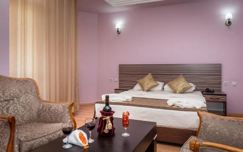 Habitación de hotel con cama y mesa con copas de vino en Zel Hotel, en Antalya