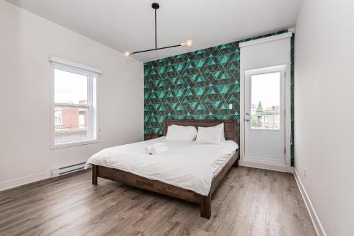 a bedroom with a bed with a green accent wall at 2 Bedroom Luxury in the Mile End by Den Stays in Montréal