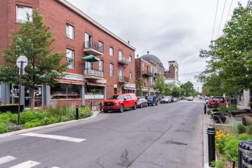 a street with cars parked on the side of a building at 2 Bedroom Luxury in the Mile End by Den Stays in Montréal