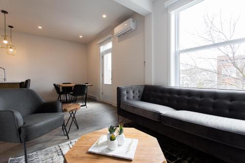 een woonkamer met een bank en een tafel bij Light Filled 2 Bdr Unit in Mile End by Den Stays in Montreal