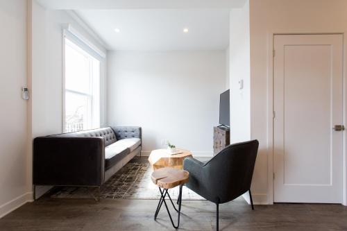 a living room with a couch and a table at Light Filled 2 Bdr Unit in Mile End by Den Stays in Montréal