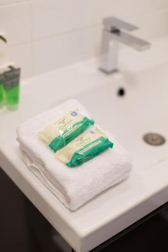 a package of toothpaste sitting on a pile of towels at Light Filled 2 Bdr Unit in Mile End by Den Stays in Montréal