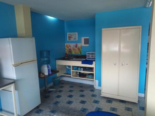 a kitchen with blue walls and a white refrigerator at Casa Azul Aragon in Mexico City