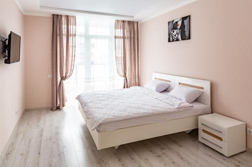Habitación blanca con cama y ventana en Lux Apartment Avalon, en Goloskovka