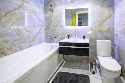 y baño con bañera, aseo y lavamanos. en Lux Apartment Avalon, en Goloskovka