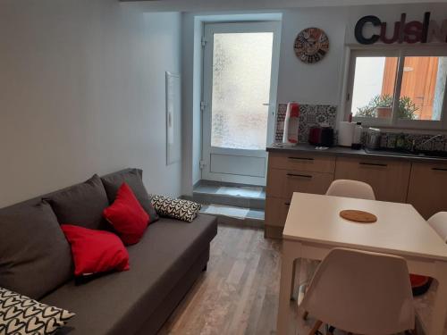 ein Wohnzimmer mit einem Sofa und einer Küche in der Unterkunft chez le tit in Mèze