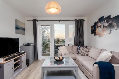 a living room with a couch and a tv at Classy Cricklewood Home in London