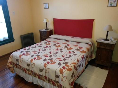 a bedroom with a bed with a red head board at Hostería Restaurante del Puerto in Colón