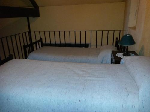 a bedroom with two beds and a table with a lamp at Hostería Restaurante del Puerto in Colón