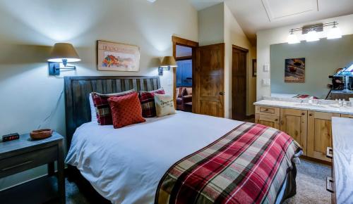 a bedroom with a large bed and a sink at Bear Claw 508 - True Ski-in Ski-out Access, Slope Views & Winter Shuttle! in Steamboat Springs