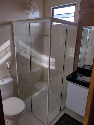 a glass shower in a bathroom with a toilet at Residencial Secret Point in Praia do Frances