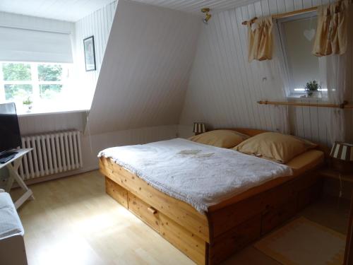 a bedroom with a wooden bed in a room at Appartement Dorfstrasse in Glücksburg