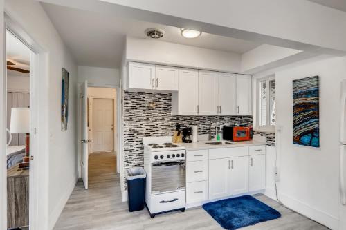 a kitchen with white cabinets and a brick wall at Tropical Getaway/ Stunning 2BR Gem in West Palm Beach