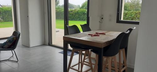 une salle à manger avec une table et des chaises et une fenêtre dans l'établissement Petite maison plain-pied, proche des plages, à Loctudy