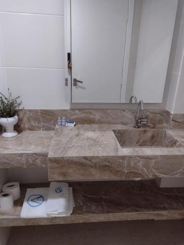 a bathroom with a large marble sink with two towels at Antonio's Hotel e Spa - Airport in Brasilia