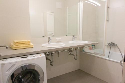 ein Badezimmer mit 2 Waschbecken und einer Waschmaschine in der Unterkunft New, quiet flat next to U1, VIC, shopping mall,... in Wien