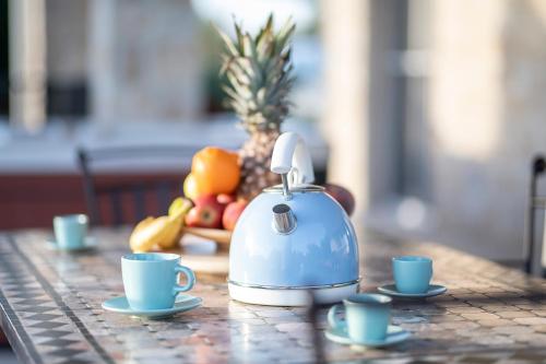 a tea kettle sitting on a table with two cups at Island Villa Adriana with heated pool and sauna in Lun