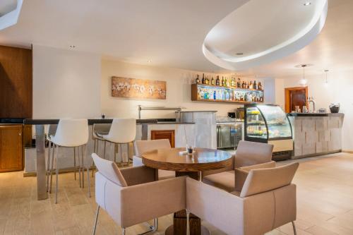 a kitchen with a table and chairs and a counter at JOIA Rose Hall by Iberostar - Adults Only All Inclusive Resort in Montego Bay