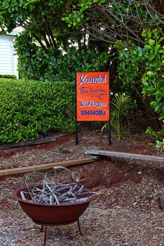 a sign that is next to a wheelbarrow with a bowl at Camelot Boutique Accommodation in Mount Tamborine