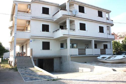 a building with a boat in front of it at Batkoski Apartments in Pag