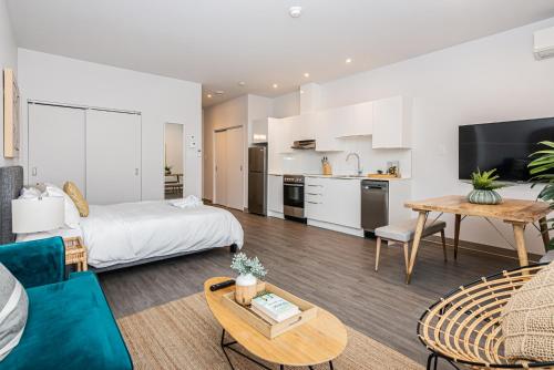 a living room with a bed and a kitchen at Brand New and Perfectly Located Flat in Le Plateau by Den Stays in Montréal
