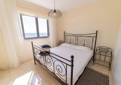 a bedroom with a black bed and a window at Castle apartment in Paphos City