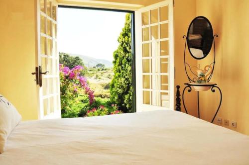 a bedroom with a door open to a garden at Fabulosa Quinta do Vento in Palmela