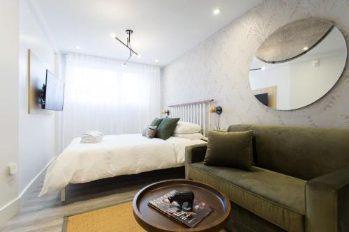 a bedroom with a bed and a couch and a mirror at Serene and Styled Little Italy Studio full bath by Den Stays in Montréal