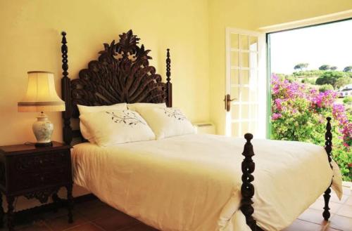 um quarto com uma cama grande e uma janela grande em Fabulosa Quinta do Vento em Palmela