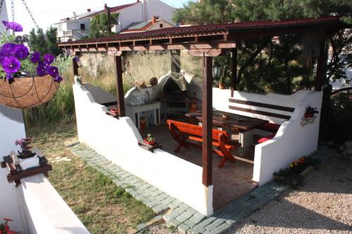 a patio with a wooden table and a bench at Batkoski Apartments in Pag