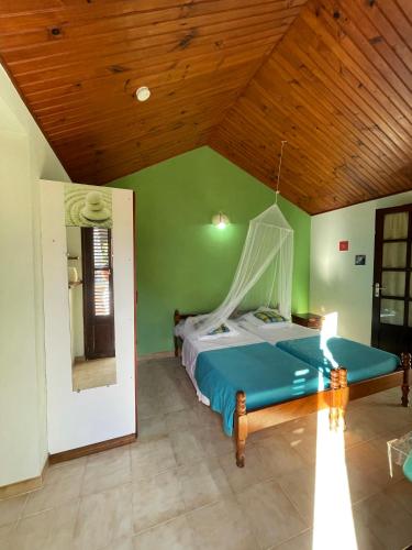 a bedroom with a bed in a room with a wooden ceiling at Résidence Sucrerie Motel - Les Anses-d'Arlets - Martinique in Les Anses-dʼArlets