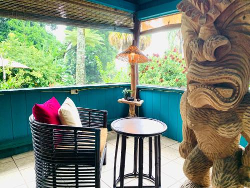 eine Veranda mit einem Tisch und Stühlen sowie einer Elefanten-Statue in der Unterkunft Wild Ginger Hotel in Hilo