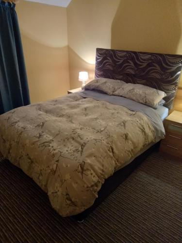 a bedroom with a large bed with a brown comforter at 3 bed corner terrace house by the sea Wicklow town in Wicklow